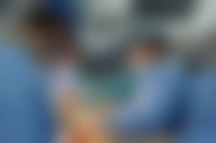 Fotografía clínica difuminada del equipo quirúrgico durante un trasplante pulmonar — clic para revelar
